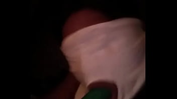 Sucking on a green dildo with mouth mask