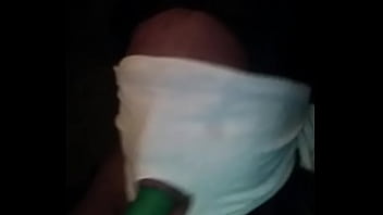Sucking on a green dildo with mouth mask