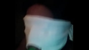 Sucking on a green dildo with mouth mask