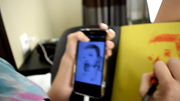 Cute teen porn star drawing a picture while sitting on a bed before she gets used sexually