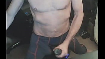 Stretching in spandex on stool with massage gun