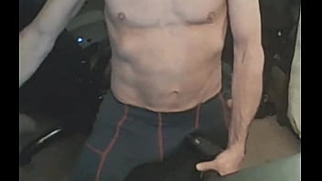 Stretching in spandex on stool with massage gun