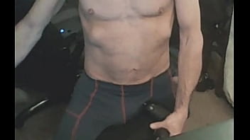 Stretching in spandex on stool with massage gun