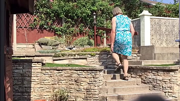 Green Dress In Garden Transvestite Pose Outdoors thumbnail