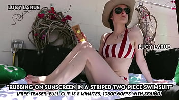 Rubbing on sunscreen in a striped two piece swimsuit