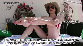 Rubbing on sunscreen in a striped two piece swimsuit