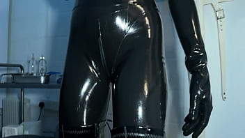 Solo 1 showcasing studio black latex catsuit and huge red cobra strap on