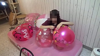 Japanese girl deflating the beachballs Japanese girl deflating the beachballs