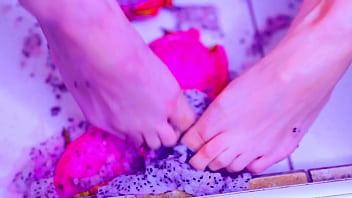 Bare toes crushing juicy fruit