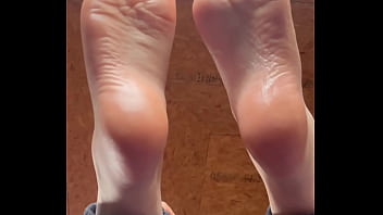 White girl takes socks off and puts lotion on her soft and clean feet