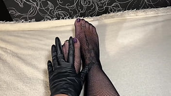 Anna wearing black gloves and fishnet stockings pleasuring herself fingering her ass and pussy