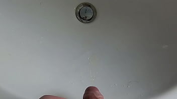 Boy is pissing in the sink and makes stinky farts