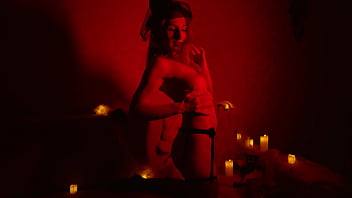 Naked beautiful witch between firing candles
