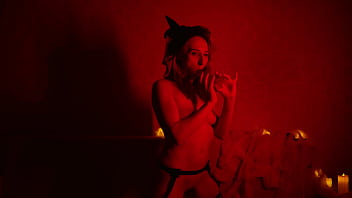 Naked beautiful witch between firing candles