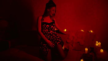 Naked beautiful witch between firing candles