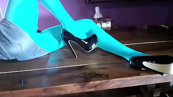 Milf with beautiful legs in pantyhose and heels lying on the table