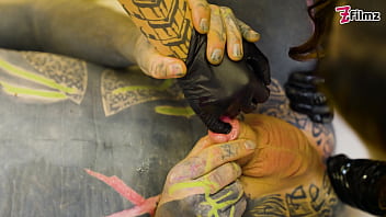 Two dominatrix fist slaves ass and finger his cock