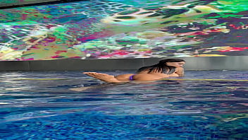 Monika Fox In Purple Bikini Swims In Pool & Poses By Window Against Background Of City Free thumbnail