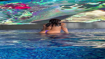 Monika fox in purple bikini swims in pool & poses by window against background of city free Monika fox in purple bikini swims in pool & poses by window against background of city free