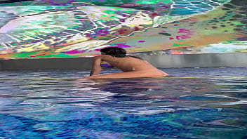 Monika fox in purple bikini swims in pool & poses by window against background of city free