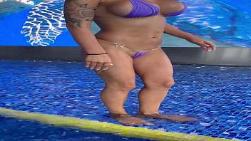 Monika fox in purple bikini swims in pool & poses by window against background of city free