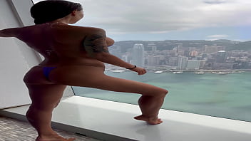 Monika fox in purple bikini swims in pool & poses by window against background of city free