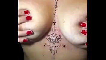 Loira com os peitos enorme mostrando sua tatuagem sem timidez