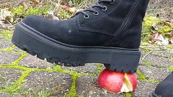 Woman crush apple underfeet