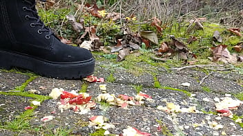 Woman crush apple underfeet