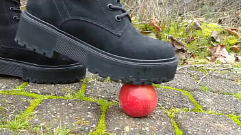 Woman crush apple underfeet