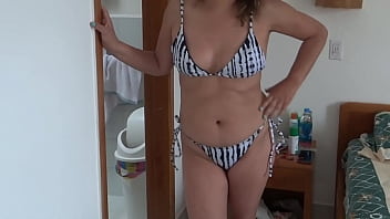 Beautiful stepmother on the beach putting on a bikini showing off looking for some guy