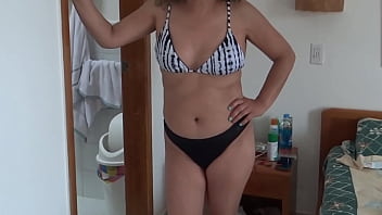 Beautiful stepmother on the beach putting on a bikini showing off looking for some guy