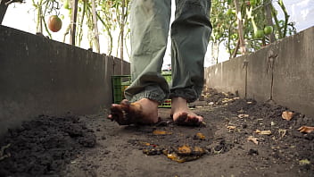 Dirty feet crushing vegetables outdoors