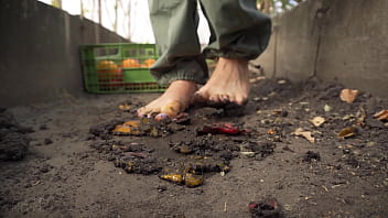 Dirty feet crushing vegetables outdoors