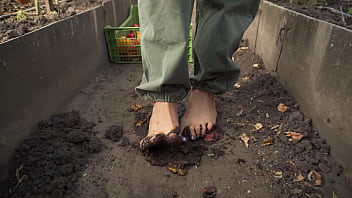 Dirty feet crushing vegetables outdoors