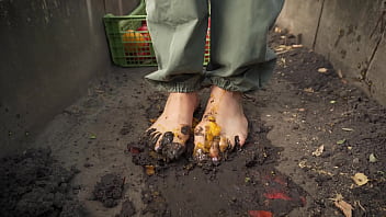Dirty feet crushing vegetables outdoors