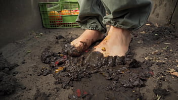 Dirty feet crushing vegetables outdoors