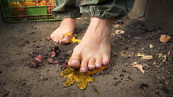 Dirty feet crushing vegetables outdoors