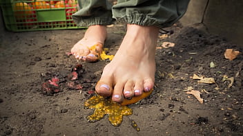 Dirty feet crushing vegetables outdoors