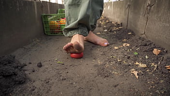 Dirty feet crushing vegetables outdoors