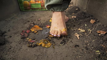 Dirty feet crushing vegetables outdoors