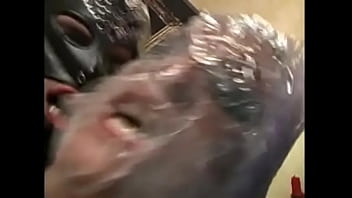 Muscular dude in a black mask fucks a naughty chick wrapped in tape