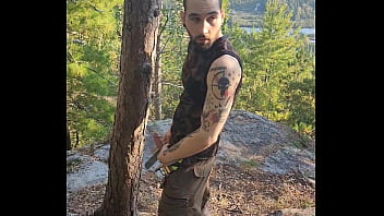 Bearded tattooed hunk blowing a load on the mountain