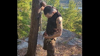 Bearded tattooed hunk blowing a load on the mountain