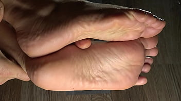 Cleaning her feets with a damp cloth and showing her green feet fingernails close up