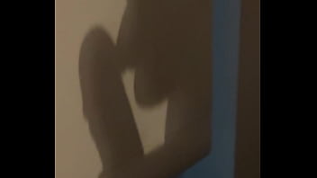 The shadow reflects her sucking his cock