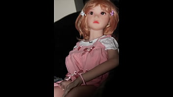 Small busty sex doll posing in pink