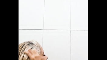 No banheiro enfiando consolo na buceta