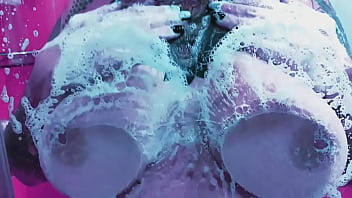 Curvy girl washes her huge tits with soap and rubs them on the glass