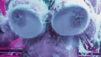 Curvy girl washes her huge tits with soap and rubs them on the glass